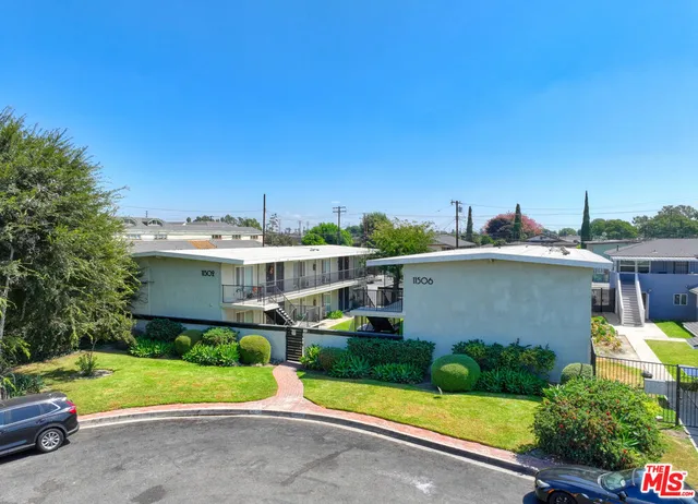 a front view of a house with a yard and potted plants
