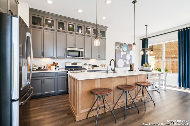 a kitchen with granite countertop a stove a sink and a refrigerator