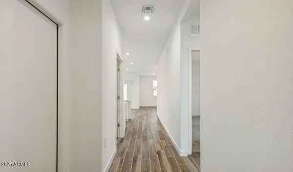 a view of a hallway with wooden floor
