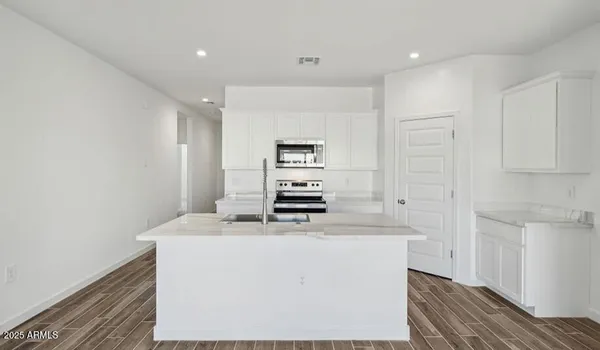 a kitchen with kitchen island a stove a sink and a refrigerator