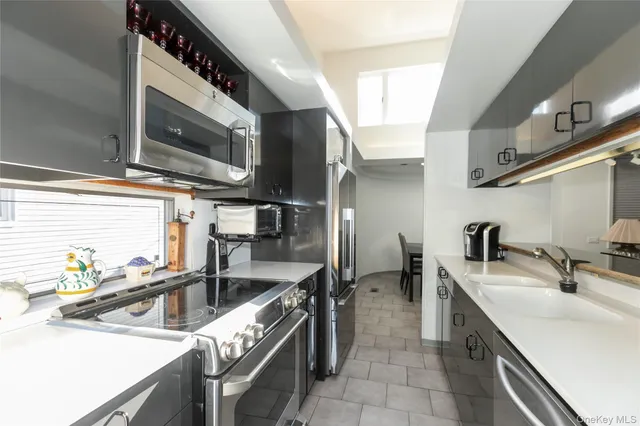 a kitchen with stainless steel appliances granite countertop a sink and a stove