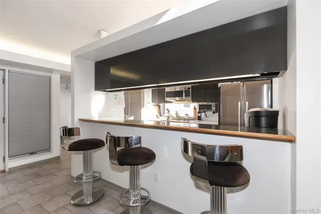 a kitchen with a sink and chairs