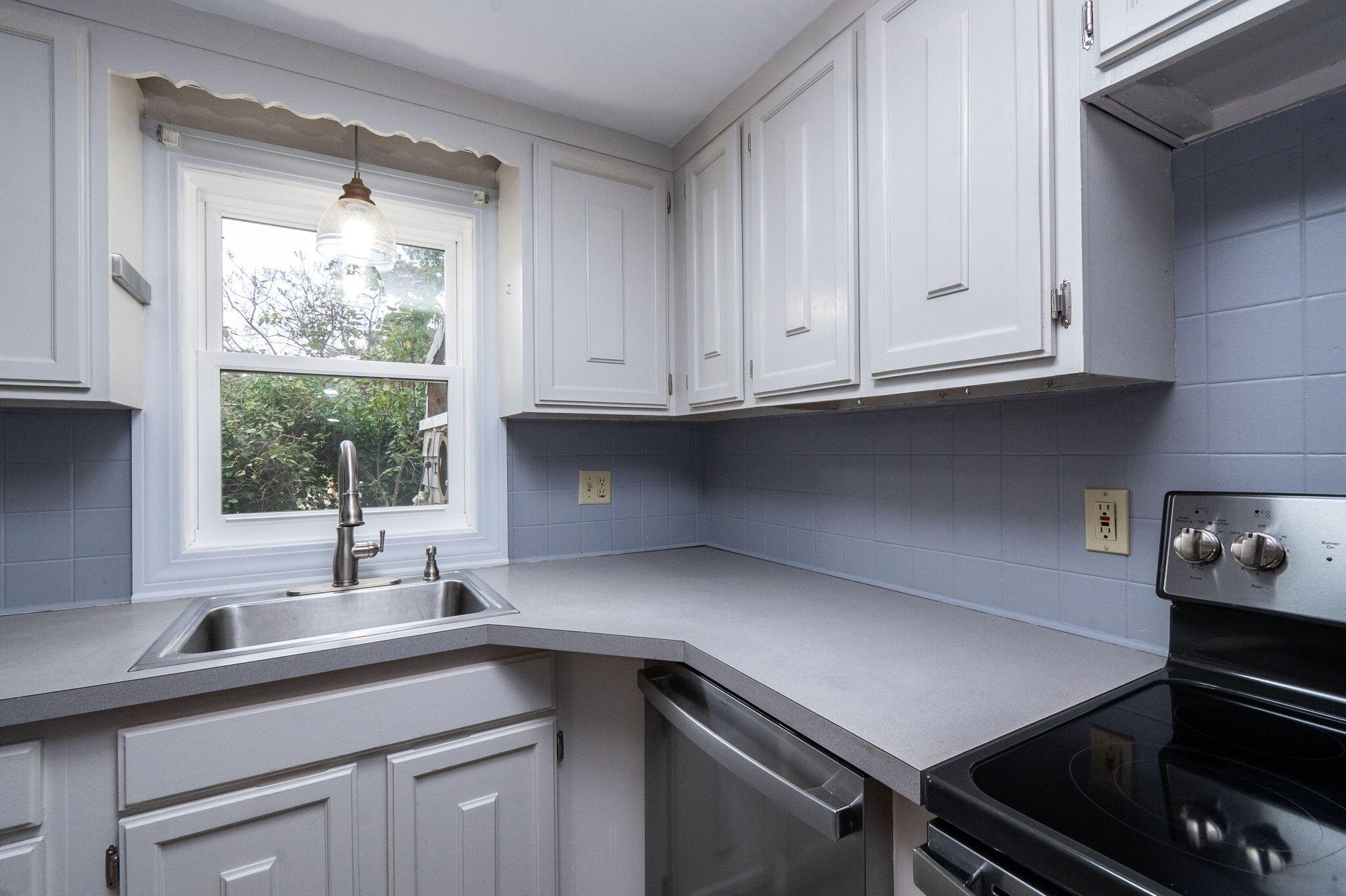 102 Sea Street Dennis Port, MA 02639 - Photo 11 of 37 a kitchen with appliances cabinets and a window