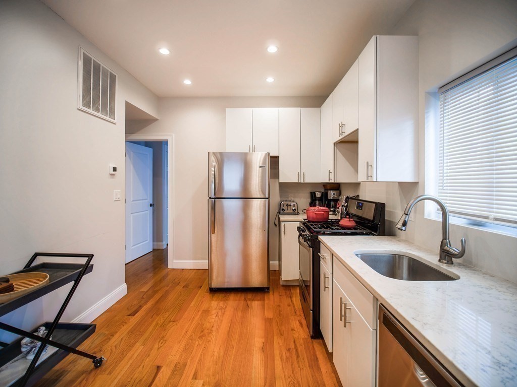 309 R Sumner Street, Unit 3 Boston, MA 02128 - Photo 5 of 16 a kitchen with a refrigerator a sink and a stove