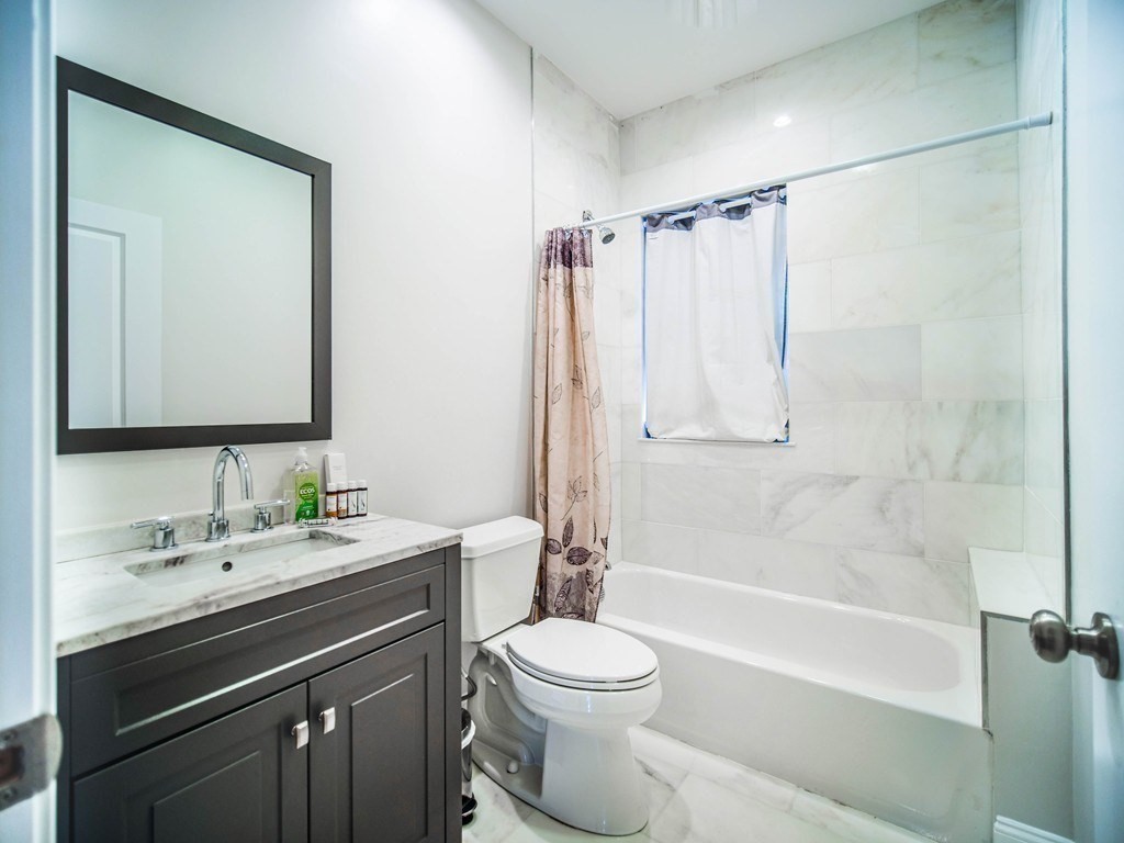 309 R Sumner Street, Unit 3 Boston, MA 02128 - Photo 8 of 16 a bathroom with a sink a toilet and a mirror