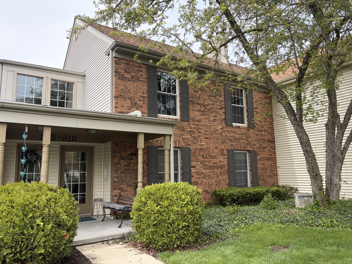 318 Dunham Place Commons, Unit 318 St. Charles, IL 60174 - Photo 2 of 20 front view of a brick house with a large windows and a large tree