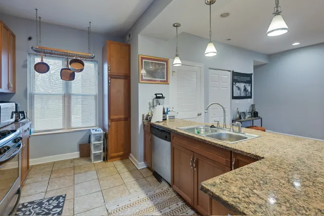 a kitchen with stainless steel appliances granite countertop a sink and a refrigerator
