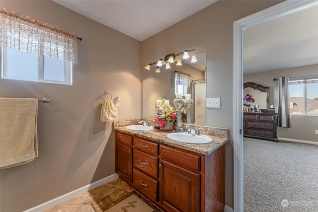 a bathroom with a granite countertop sink a light fixture and a mirror