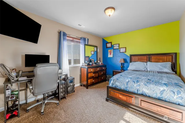 a bedroom with a bed and flat screen tv