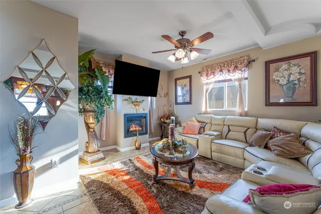 a living room with furniture a flat screen tv and a fireplace