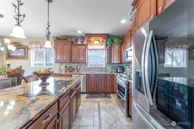 a kitchen with stainless steel appliances granite countertop a sink stove and refrigerator