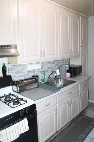 a kitchen with stainless steel appliances granite countertop a sink stove and cabinets