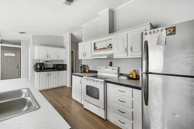 a kitchen with white cabinets and white appliances