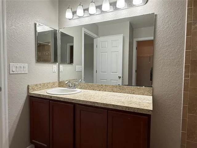 a bathroom with a granite countertop sink and a mirror