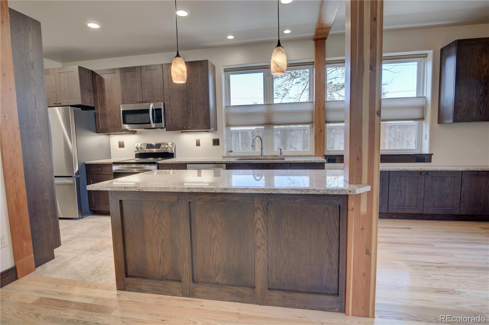 315 G Street Salida, CO 81201 - Photo 5 of 43 a kitchen with stainless steel appliances granite countertop a refrigerator a sink a stove and a wooden floors