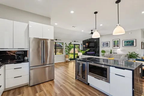 a kitchen with stainless steel appliances granite countertop a stove a refrigerator and a sink