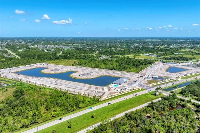 an aerial view of residential houses with outdoor space and trees