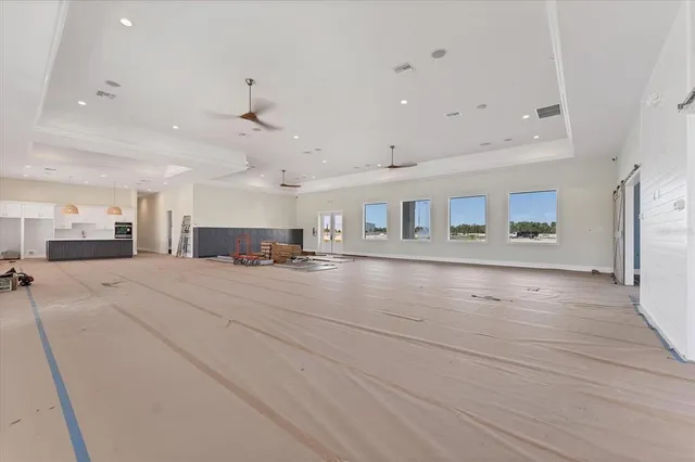 an empty room with a ceiling fan and window