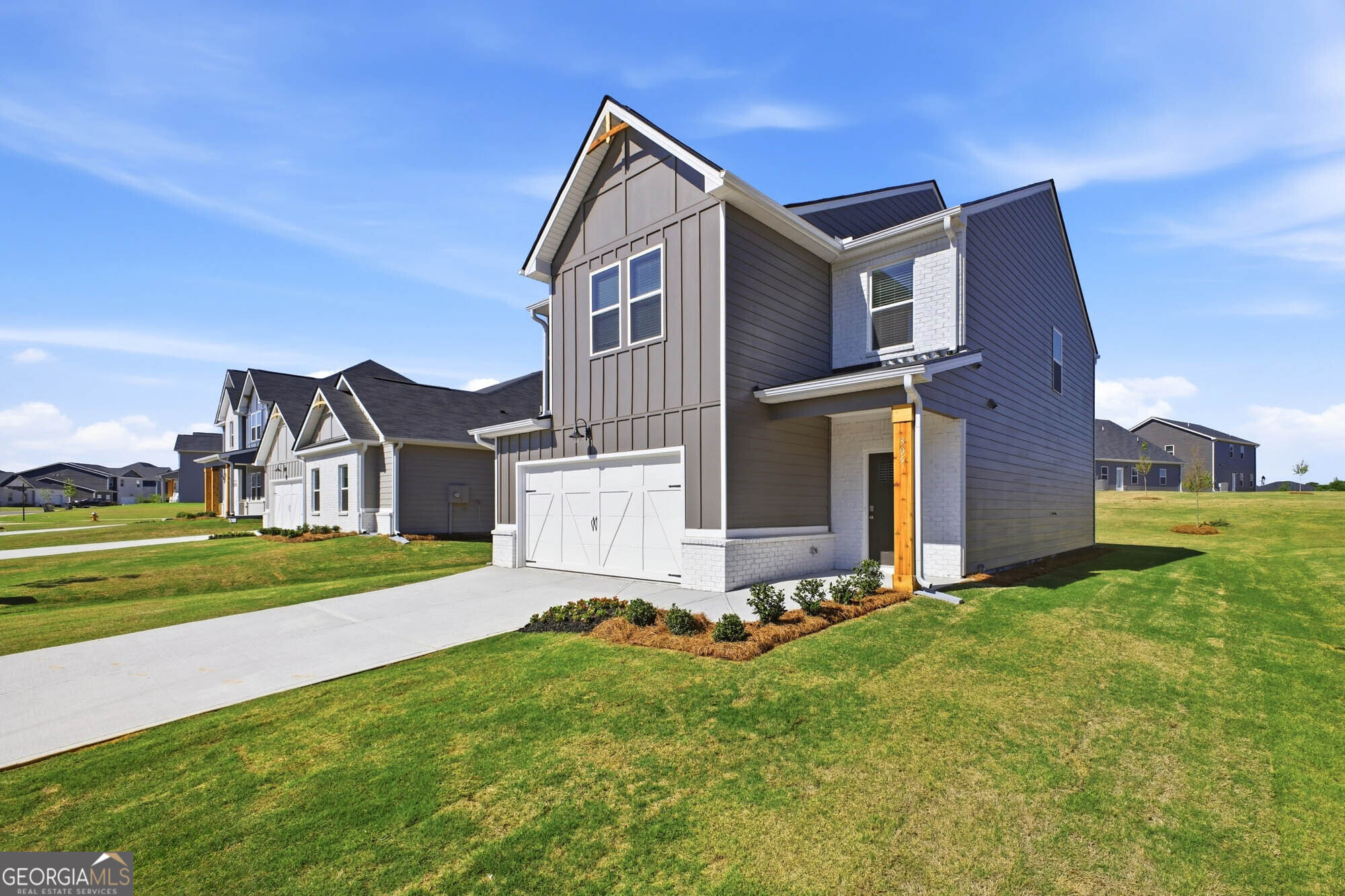 305 Rusty Plow Lane, Unit 13 Perry, GA 31069 - Photo 2 of 24 a front view of a house with a yard and garage