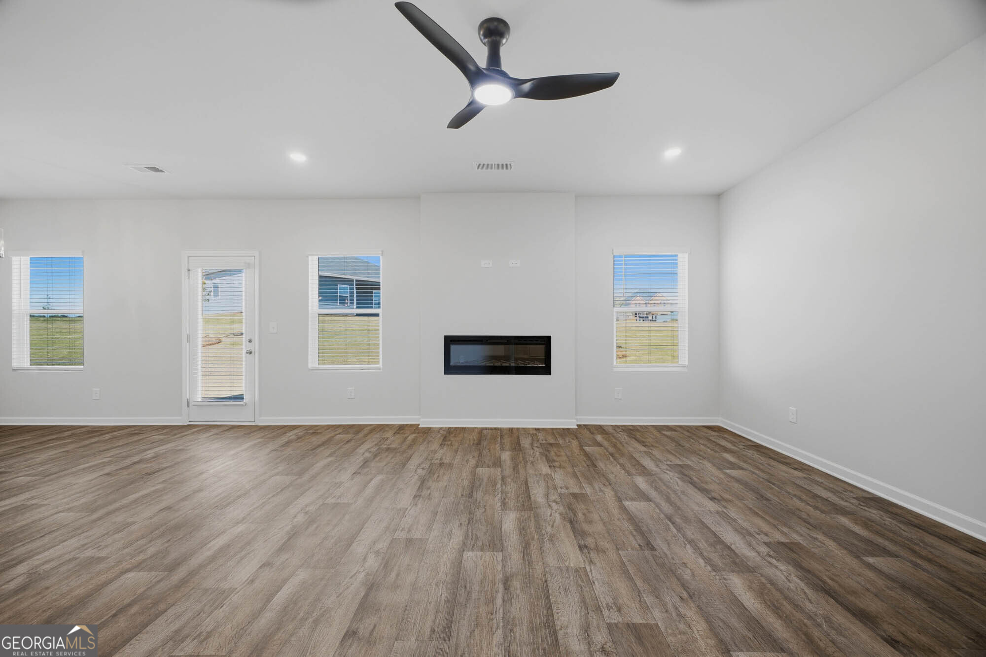 305 Rusty Plow Lane, Unit 13 Perry, GA 31069 - Photo 4 of 24 an empty room with wooden floor and windows