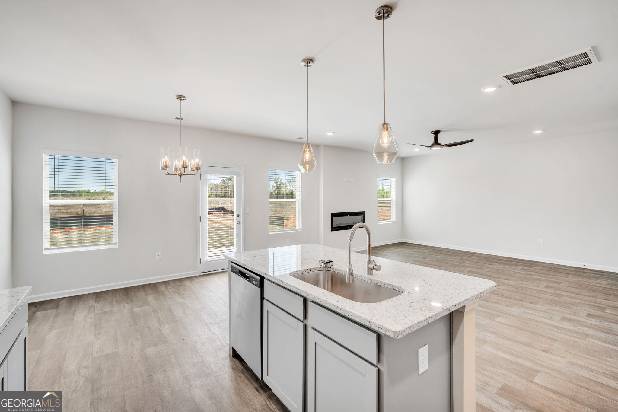 305 Rusty Plow Lane, Unit 13 Perry, GA 31069 - Photo 8 of 25 a kitchen with a sink chandelier and wooden floor