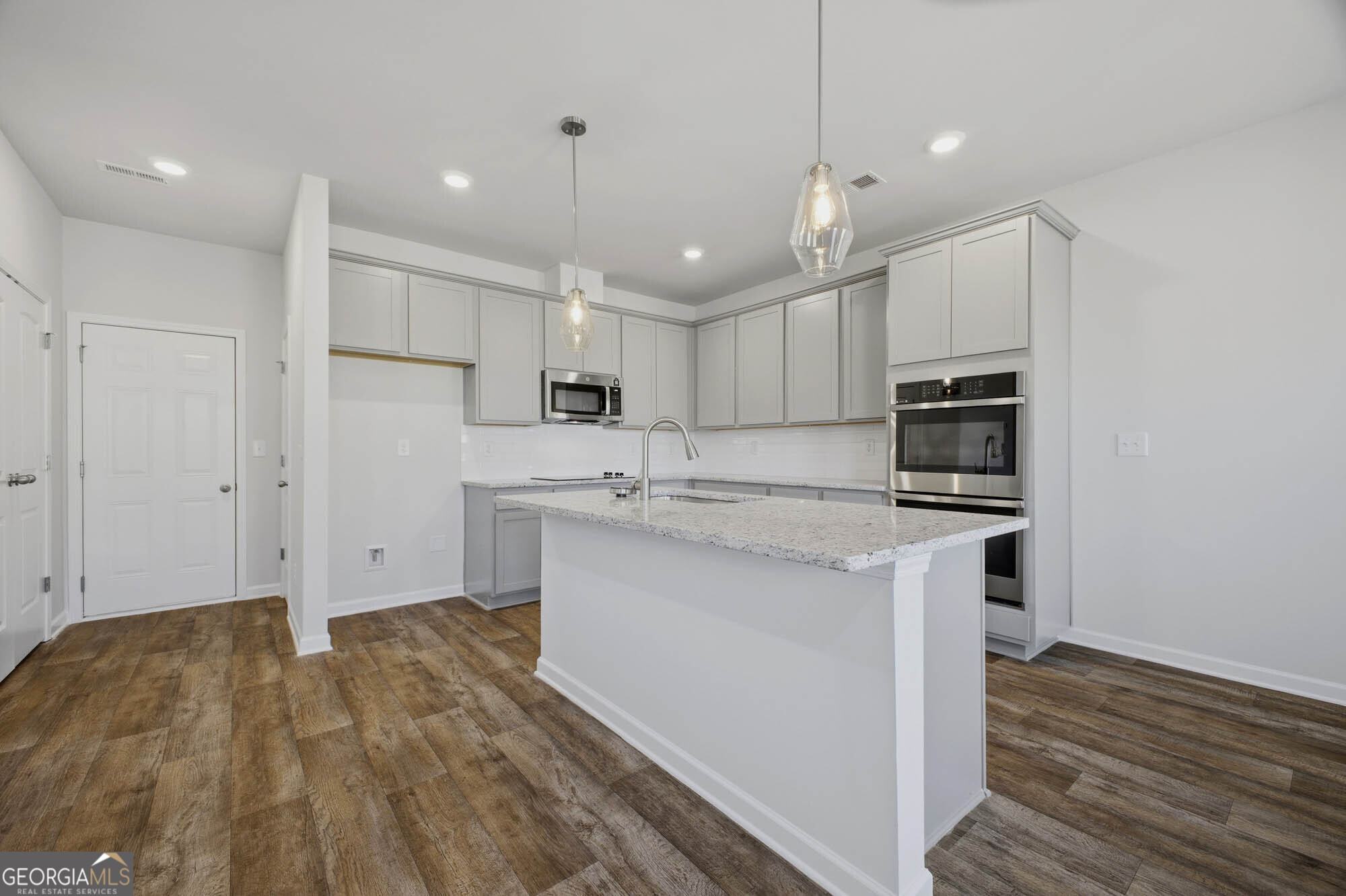305 Rusty Plow Lane, Unit 13 Perry, GA 31069 - Photo 8 of 24 a kitchen with kitchen island a sink stainless steel appliances and cabinets