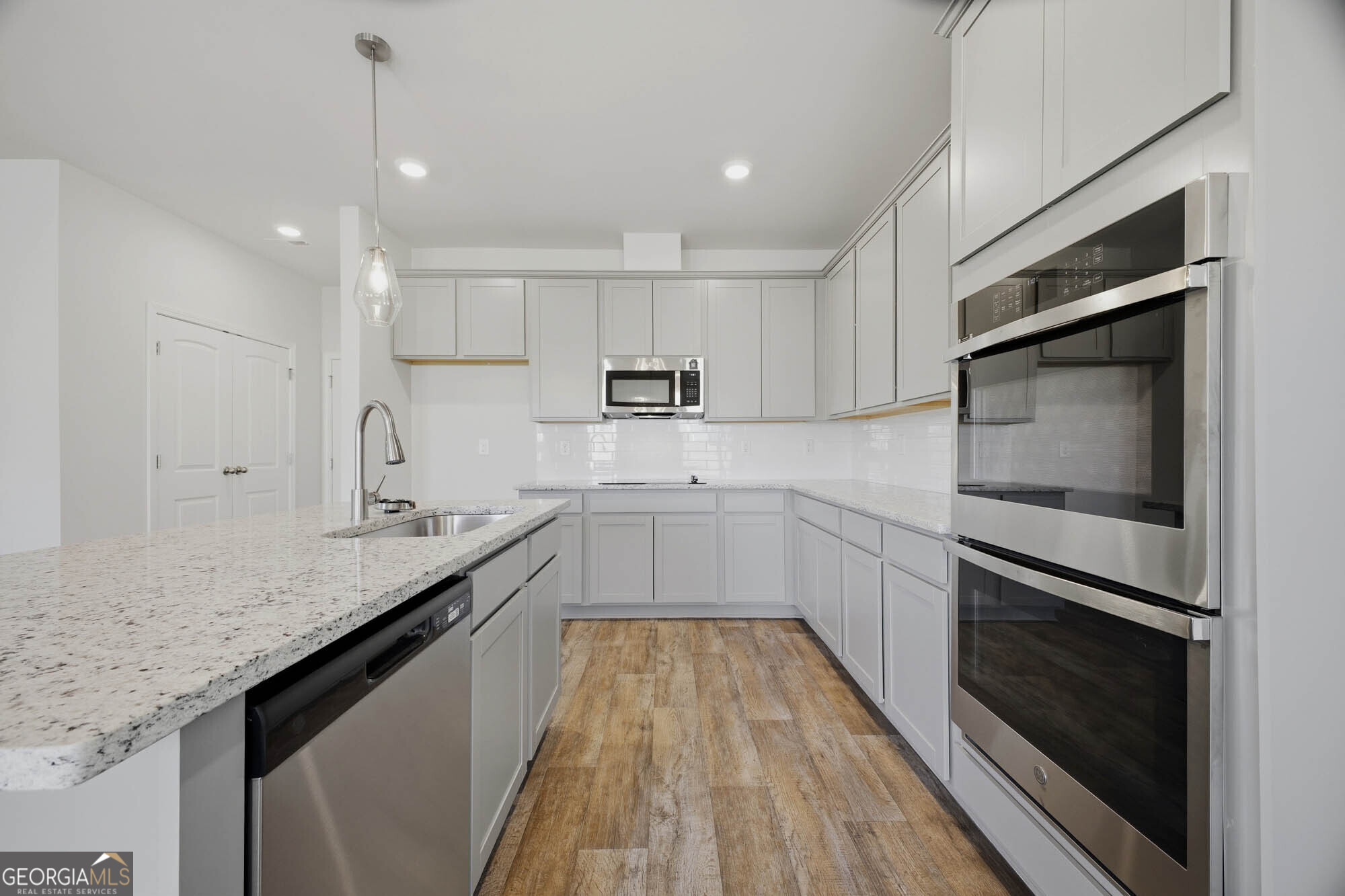 305 Rusty Plow Lane, Unit 13 Perry, GA 31069 - Photo 10 of 24 a kitchen with granite countertop kitchen island white cabinets stainless steel appliances and sink