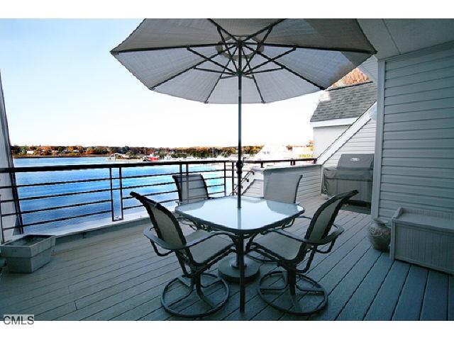 422 Popes Island Road Milford, CT 06461 - Photo 1 of 1 a view of a roof deck with table and chairs under an umbrella