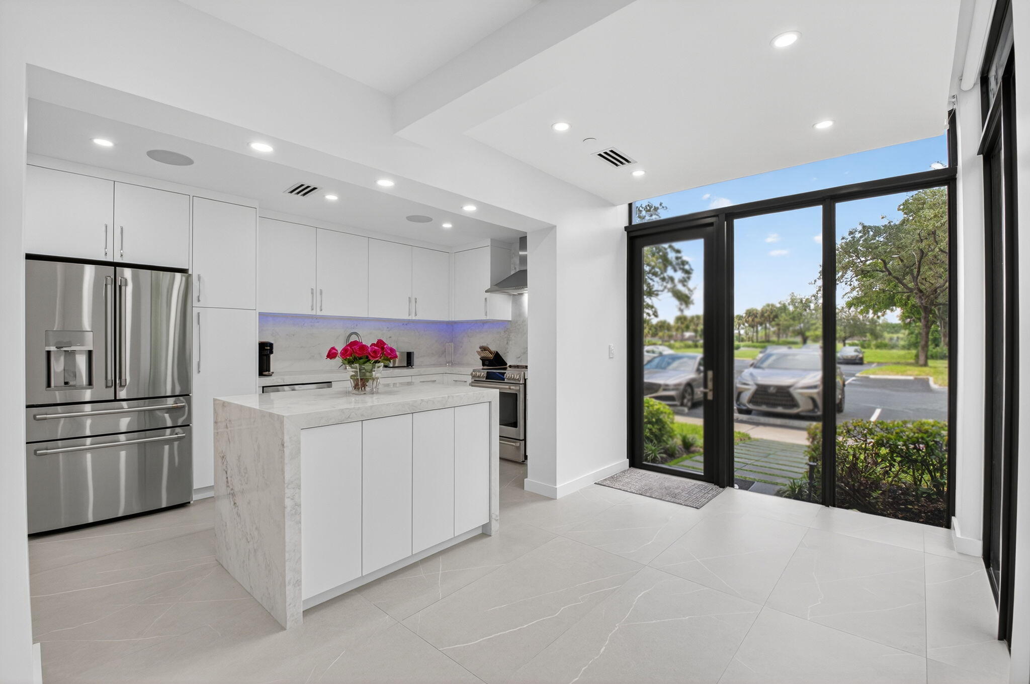 7847 Lakeside Boulevard, Unit 1014 Boca Raton, FL 33434 - Photo 7 of 53 a kitchen with refrigerator and white cabinets