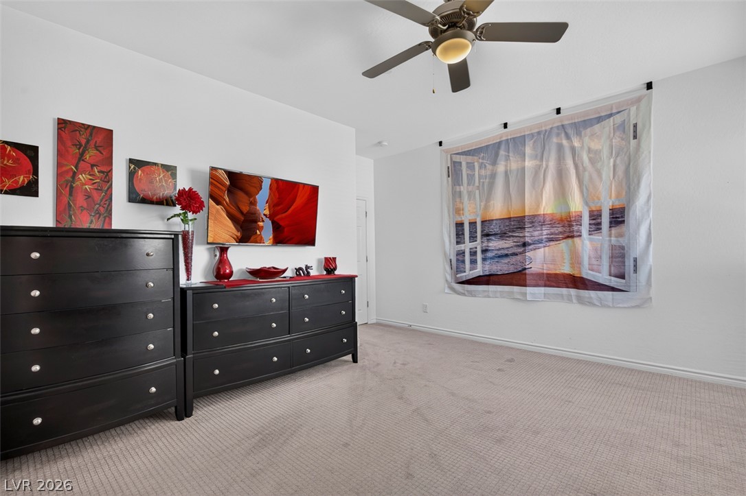 1824 Redland Ridge Street Henderson, NV 89002 - Photo 53 of 69 Relax in this well-lit bedroom featuring soft carpeting and a ceiling fan for optimal comfort.