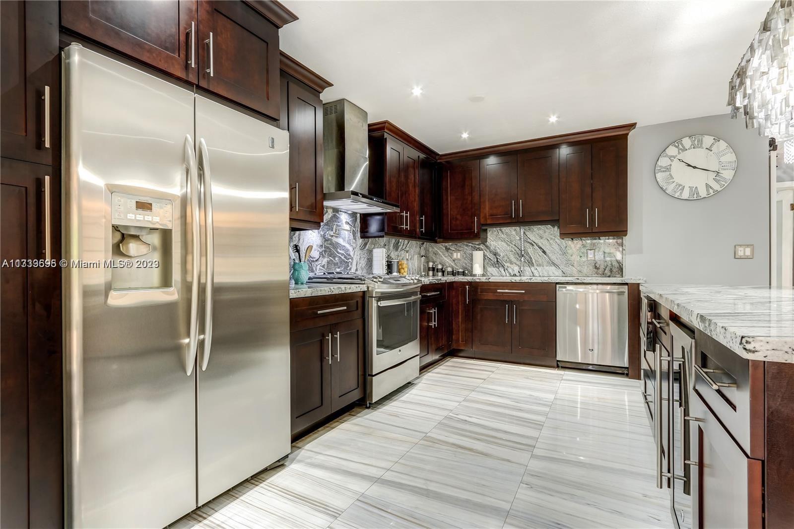 12015 Bird Road Miami, FL 33175 - Photo 4 of 16 a kitchen with stainless steel appliances granite countertop a refrigerator a stove and a sink