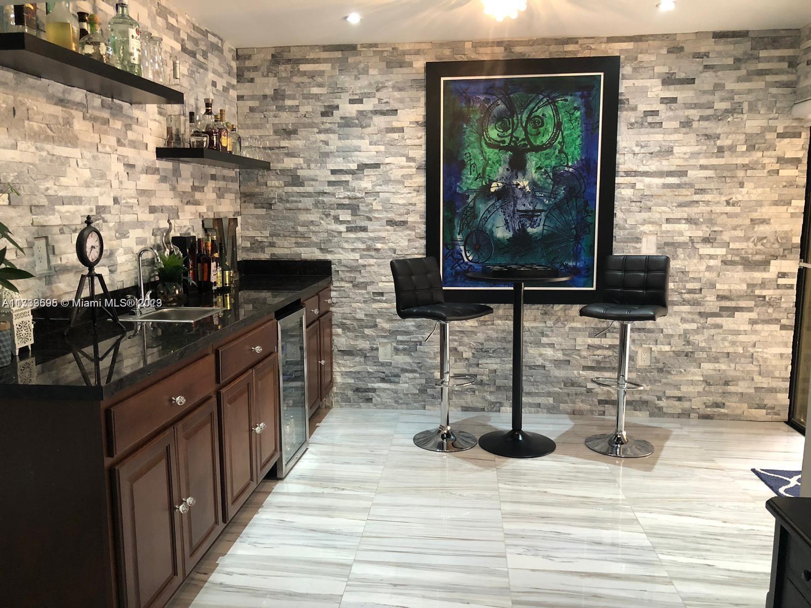 12015 Bird Road Miami, FL 33175 - Photo 5 of 16 a kitchen with stainless steel appliances kitchen island granite countertop a sink stove and wooden cabinets