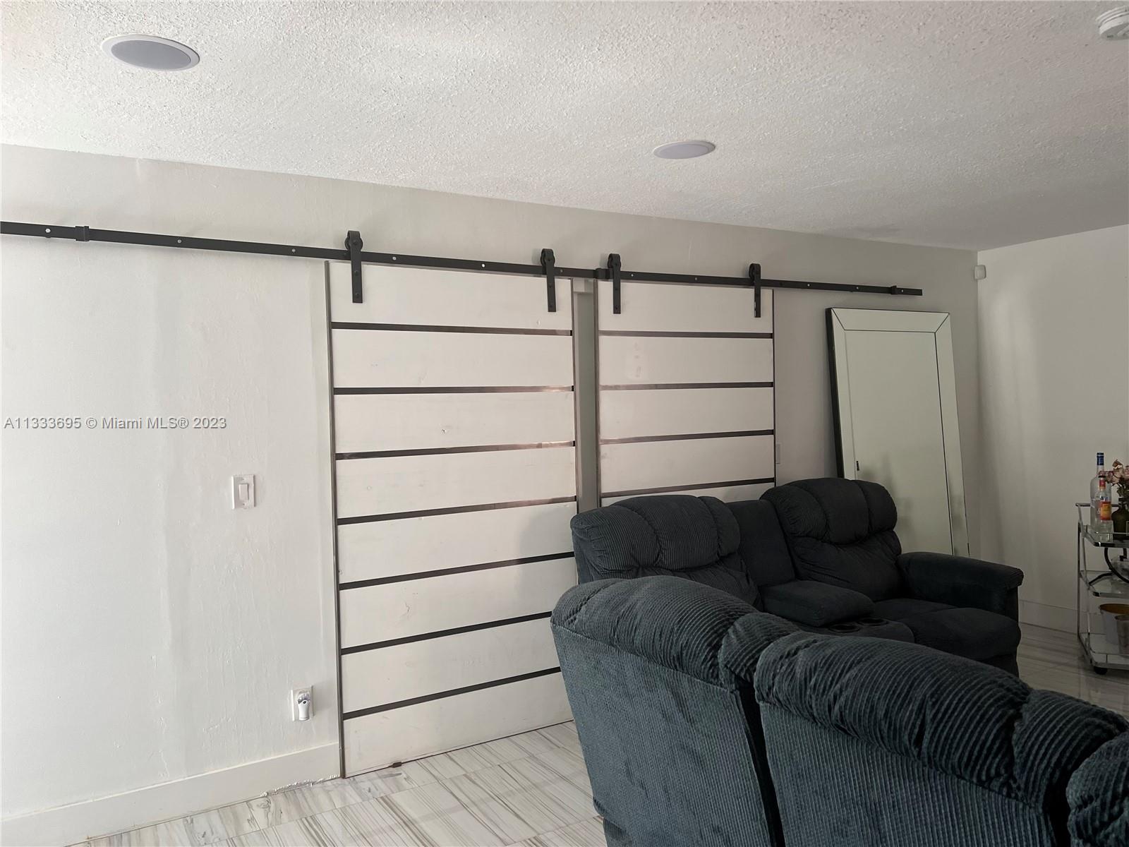 12015 Bird Road Miami, FL 33175 - Photo 9 of 16 a living room with a couch and a walk in closet
