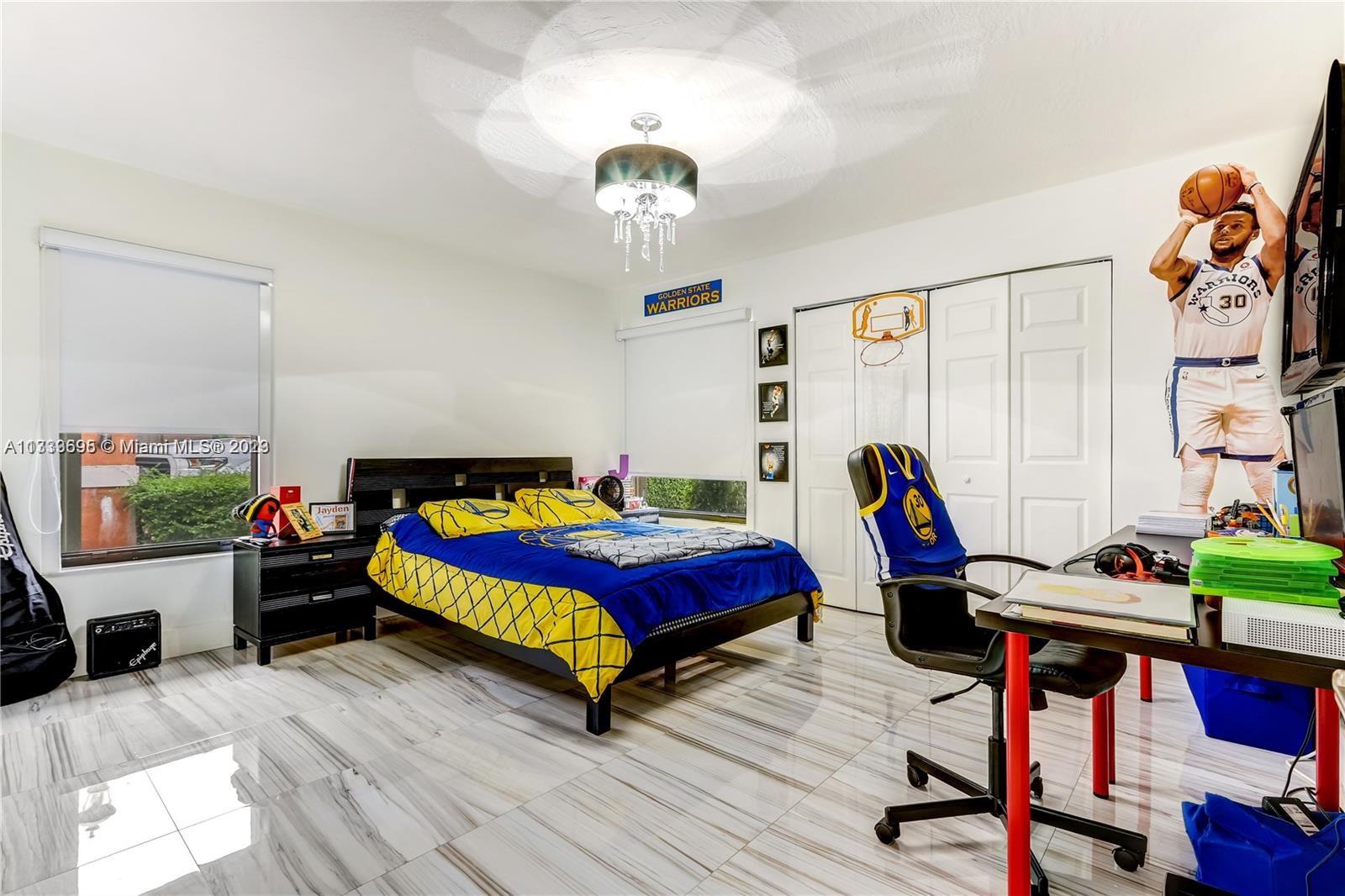 12015 Bird Road Miami, FL 33175 - Photo 10 of 16 a bedroom with bed and a chandelier