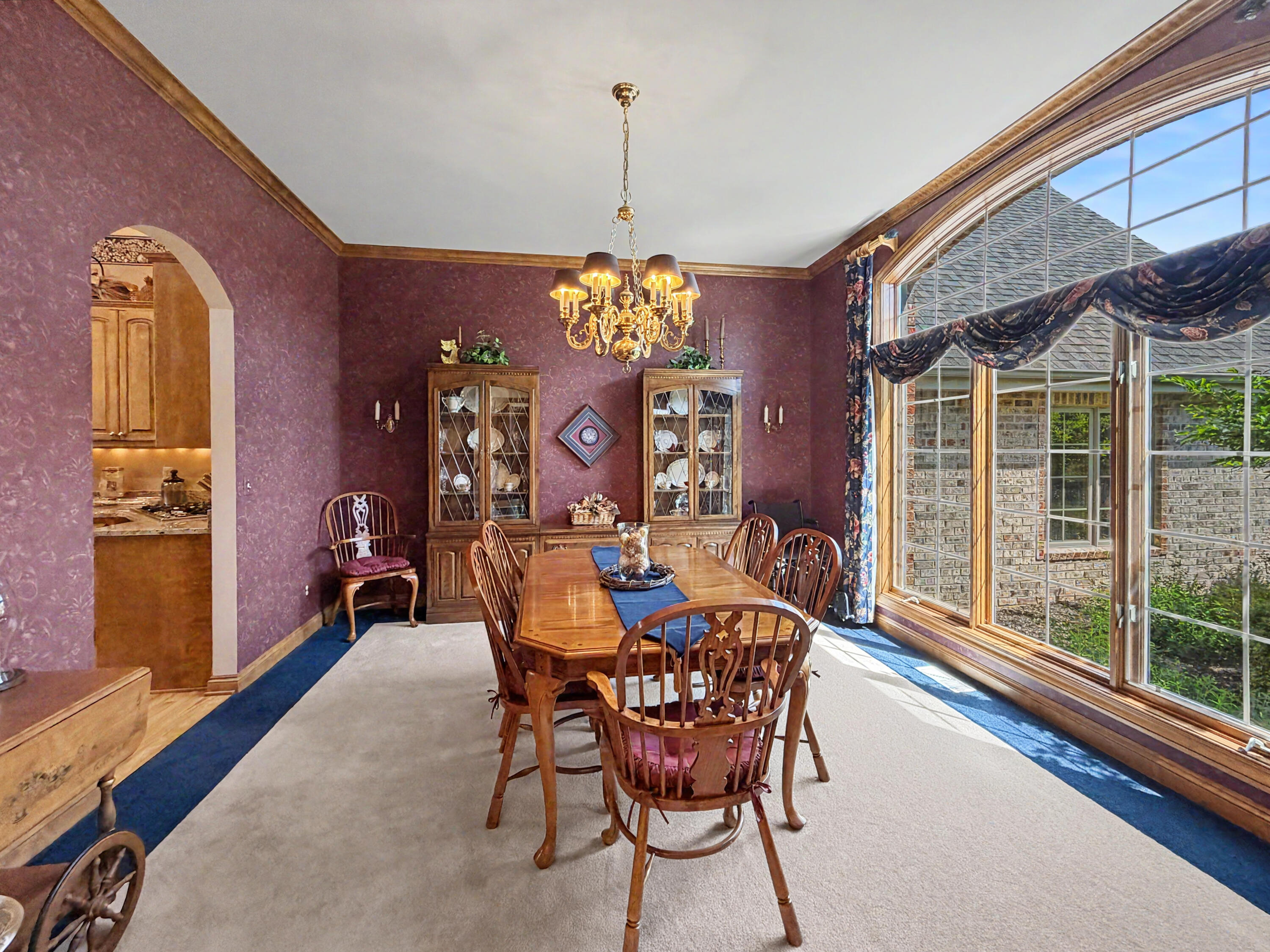 W291-s5245 Ridgefield Road Waukesha, WI 53189 - Photo 13 of 44 Spacious dining room with oversized arched window, elegant chandelier, rich wood trim, built in buffet and china cabinet and beautiful views of the landscaped front yard.
