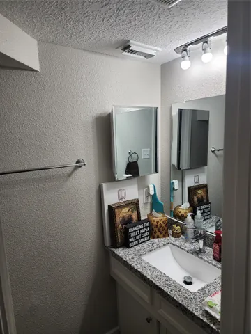 a bathroom with a granite countertop sink and a mirror