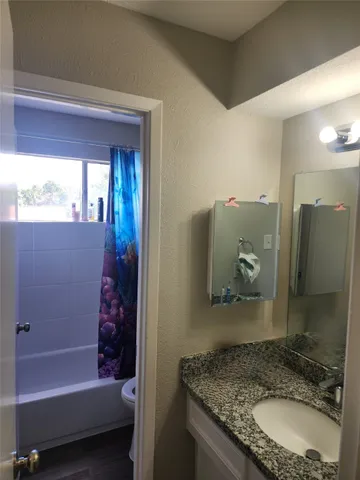 a bathroom with a granite countertop tub sink and mirror
