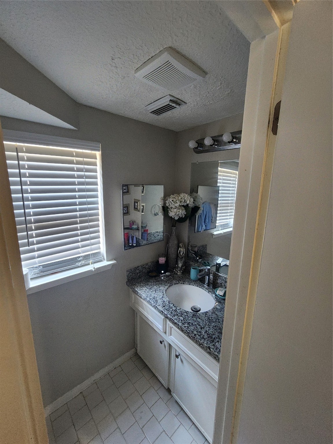 517 5th Street, Unit 4 Humble, TX 77338 - Photo 8 of 36 a bathroom with a granite countertop sink a mirror and a shower