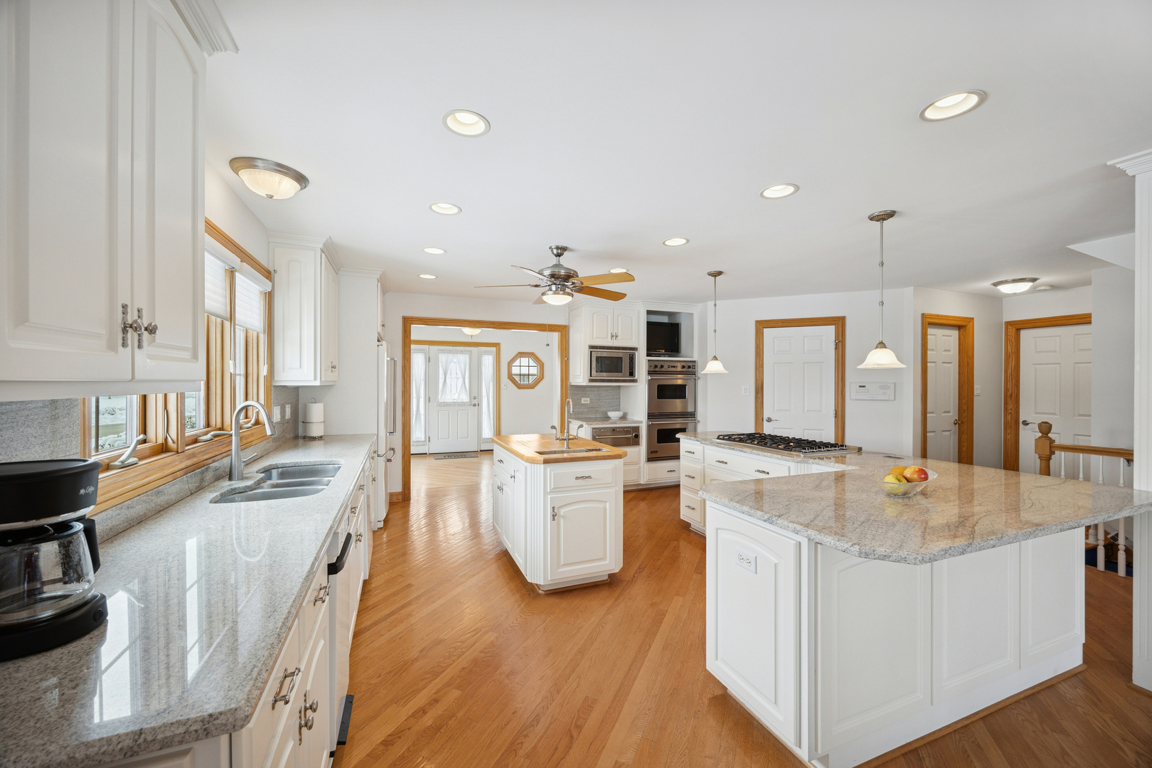 13773 Steeples Road Lemont, IL 60439 - Photo 5 of 30 a large kitchen with kitchen island a stove a sink a oven and a dining table with wooden floor