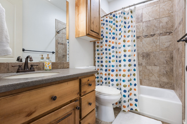 882 Sego Lily Way Mapleton, UT 84664 - Photo 13 of 41 Bathroom featuring a wood-finish vanity with a built-in sink, dark countertop, and bronze-finish fixtures