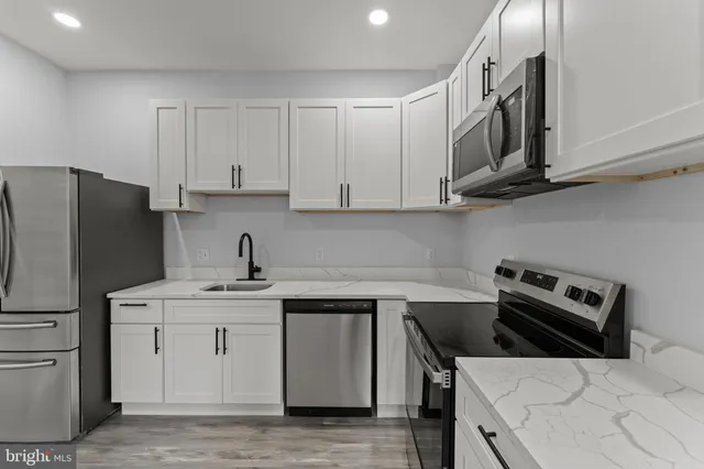 a kitchen with a sink a stove and cabinets
