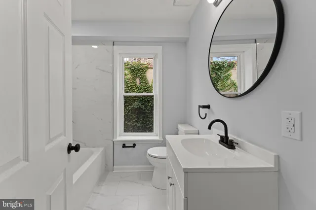 a bathroom with a toilet sink and a mirror