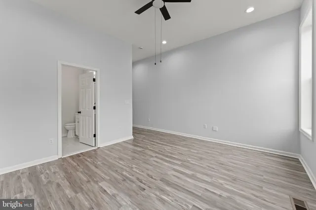 wooden floor in an empty room with a ceiling fan