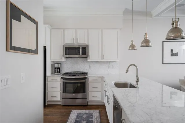 a kitchen with stainless steel appliances granite countertop a sink a stove a microwave and refrigerator