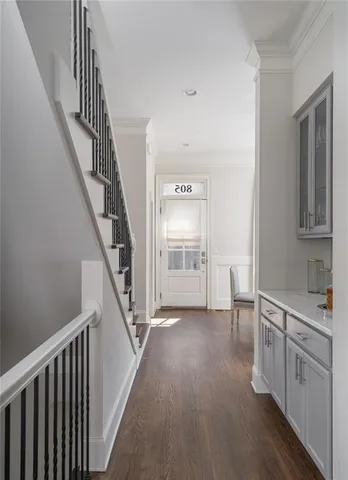 a view of hallway with stairs and wooden floor