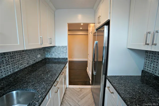 a kitchen with granite countertop a refrigerator and a sink