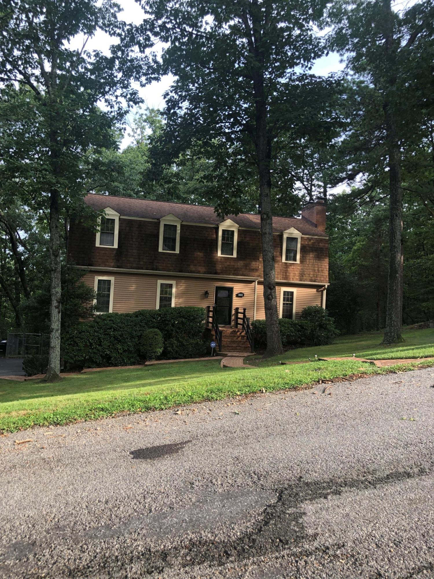 a front view of a house with a yard and trees