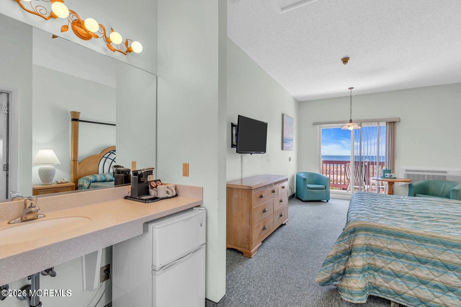 1008 Ocean Avenue Point Pleasant, NJ 08742 - Photo 20 of 29 a spacious bedroom with a bed a flat screen tv and a dresser