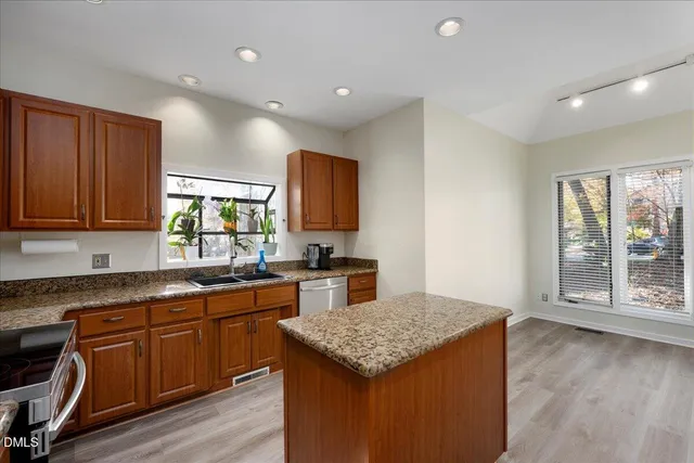 a kitchen with a stove a sink a microwave a dining table and chairs