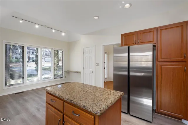 a kitchen with stainless steel appliances granite countertop a refrigerator and a sink